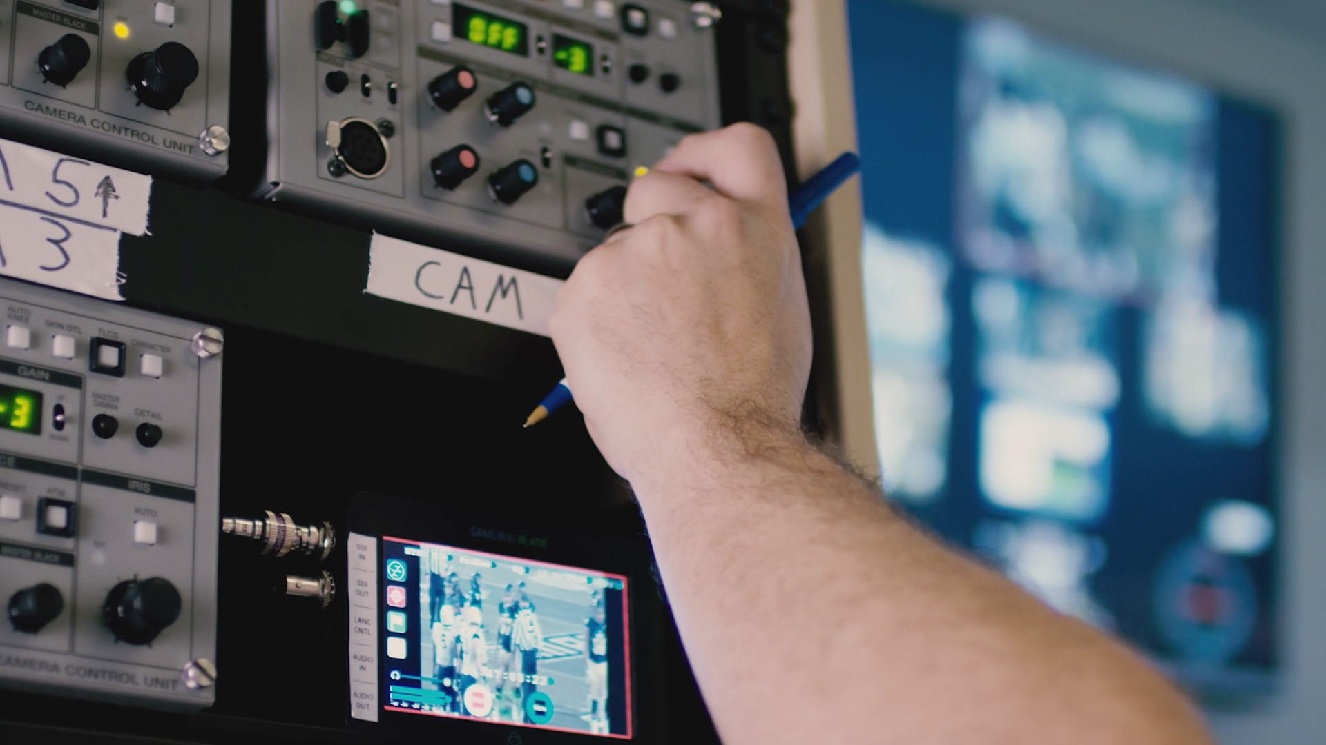 Close-up of hand turning knob on sports control room panel